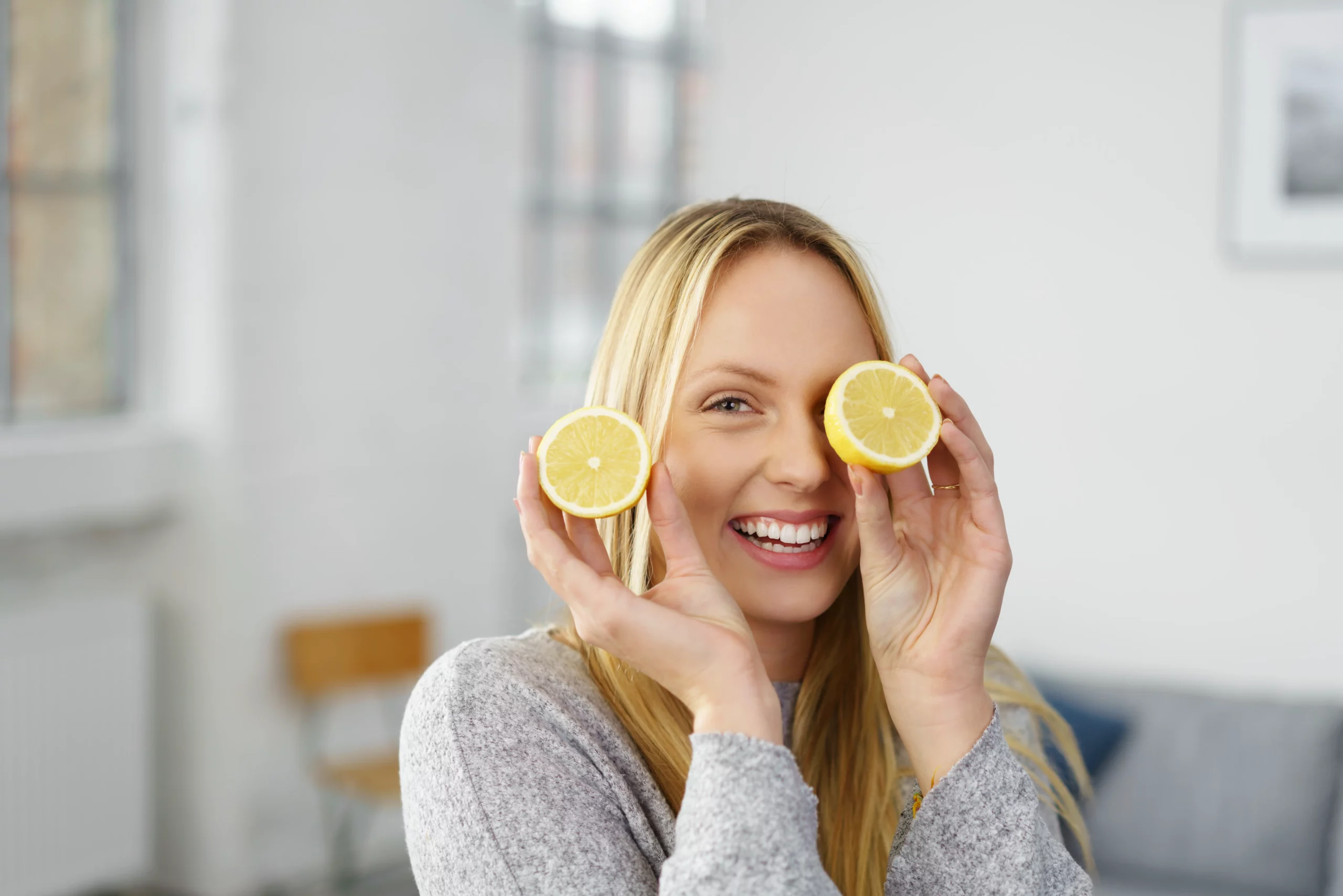 Frau hat Zitrone vors Gesicht